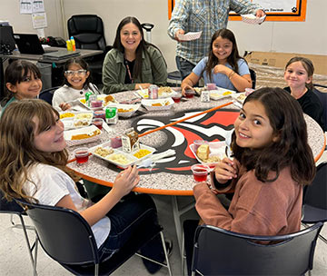 Students and staff sitting at a table for lunch Students and staff sitting at a table for lunch