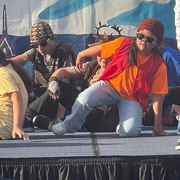 Students in costume and sunglasses doing a dance on stage Students in costume and sunglasses doing a dance on stage