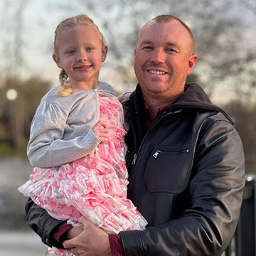 A father holding his daughter and smiling A father holding his daughter and smiling