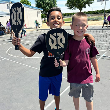 graphic-sidebar-RegistrationImmunizations Two students holding pickleball rackets