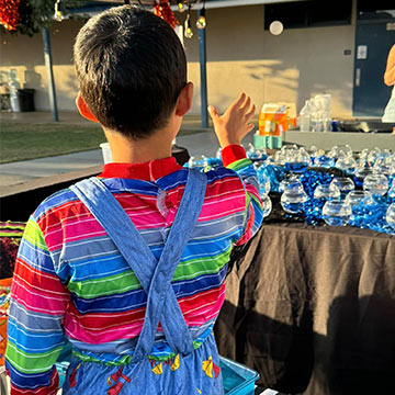 Student playing a ball toss game into fish bowls