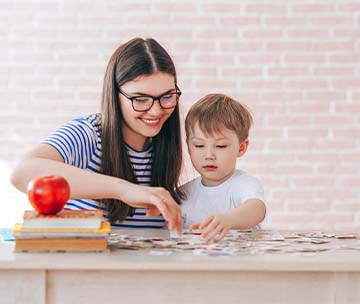 teacher and young student working on a puzzle