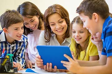 four students and a teacher working together on a tablet