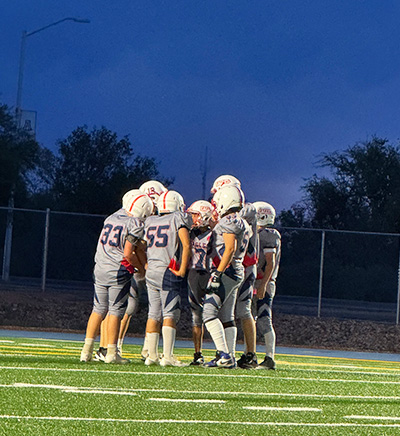 Football team in a huddle on the field