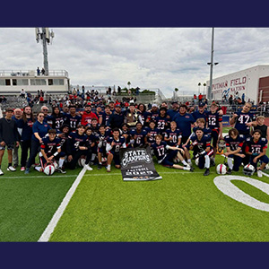 team group photo behind a state champions sign