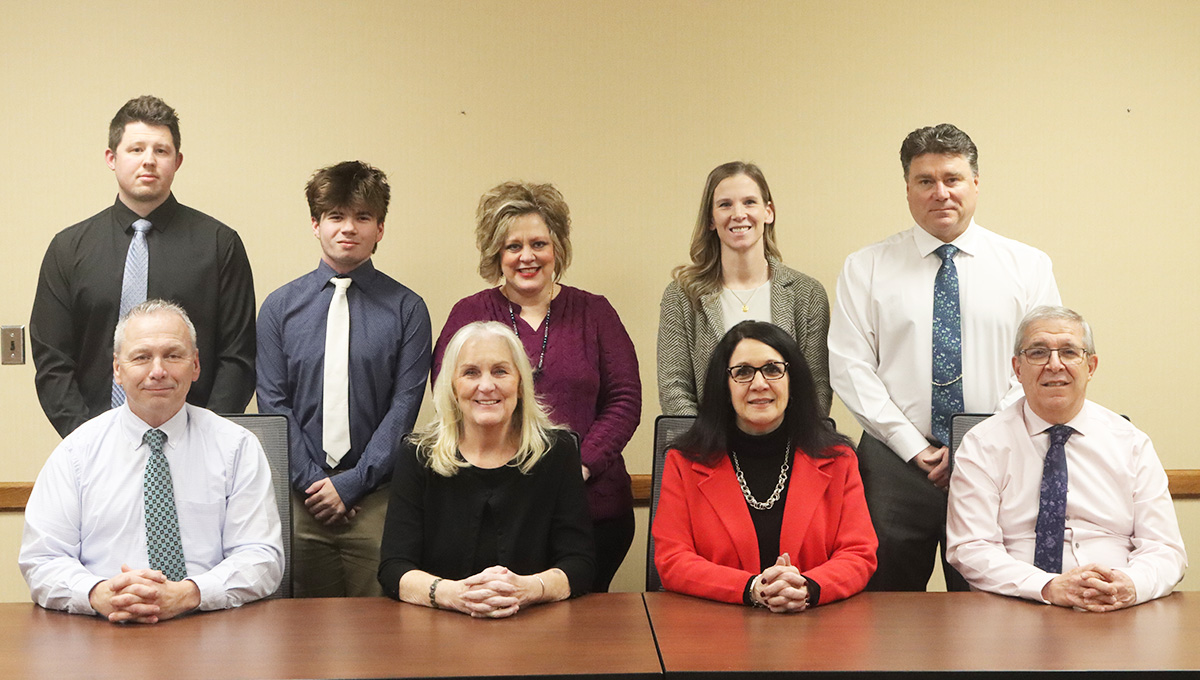 Board of Education members sitting at a conference table posing for a photo