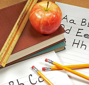 School books, apple, ruler, and pencils