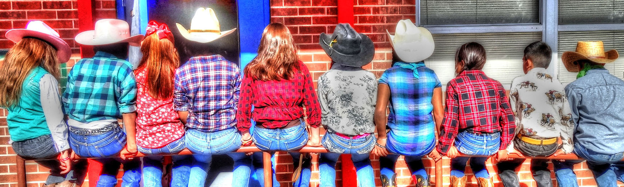 students in western wear sitting on a post