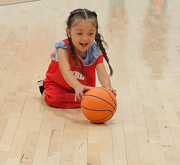 Young person grabbing for a basketball