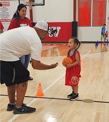 Young student with a basketball taking to an adult