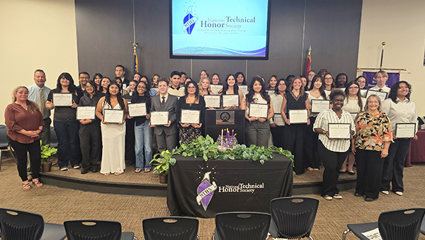 Group of National Technical Honor Society members on a stage holding certificates