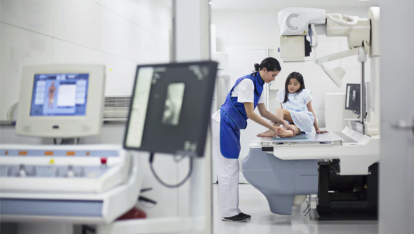 Medical student helping a patient with x-ray machine