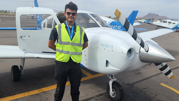 Students standing next to an airplane