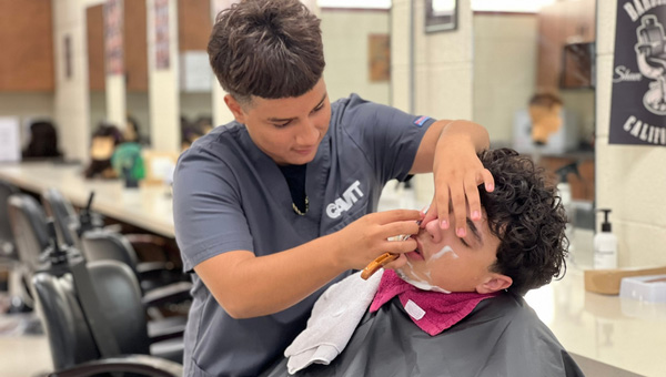 students shaving a person's face