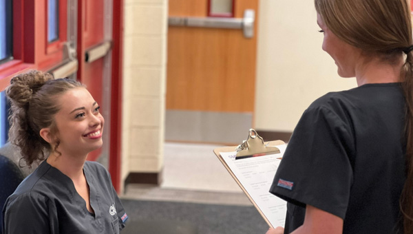 students talking and one is taking notes