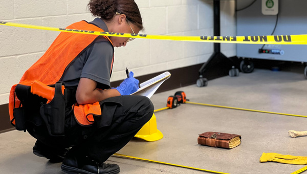student taking notes at a crime scene