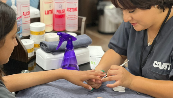 A student working on a person's fingernails