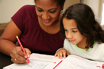 Happy woman helping a student with an assignment