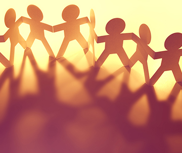 Team of paper dolls representing teamwork