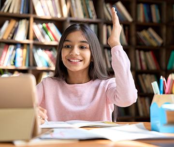 Happy school girl searching for information on her laptop