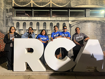 Students behind white RCA letters