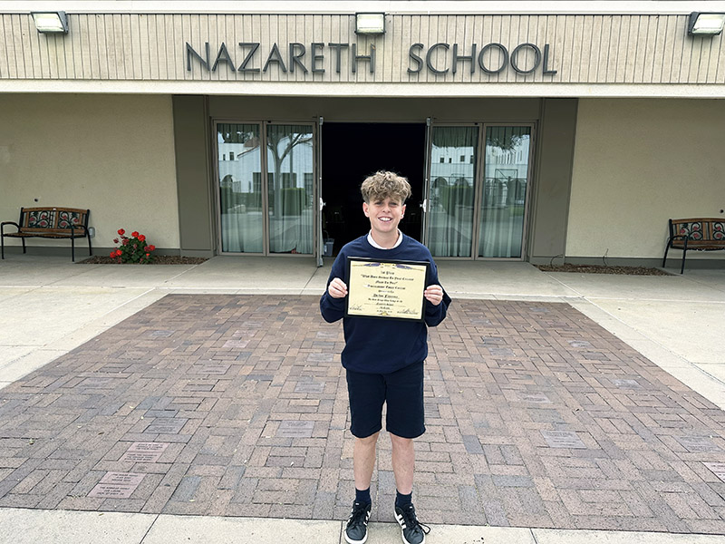 Declan Flannery proudly holding his Elk’s Lodge essay contest winner certificate