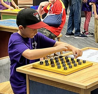 student wearing a ballcap playing chess