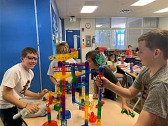students playing with a marble track