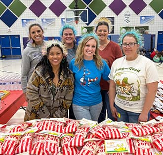 Group of happy women behind a popcorn table