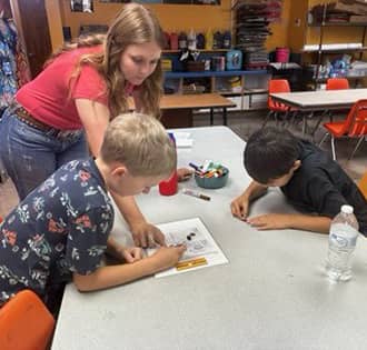 Teacher helping two students