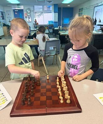 Two happy, young students enjoying a game of chess