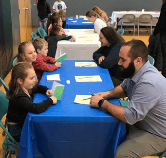 students talking to teachers at table