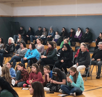 Students sitting listening to an assembly