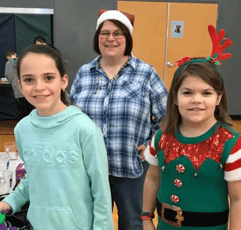 two students and teacher in christmas gear