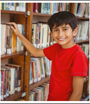 Student in library with his hand on a book on the shelf