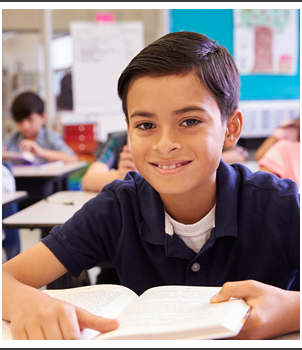 Boy in a classroom with an open book