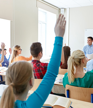 Students in class with their hands raised